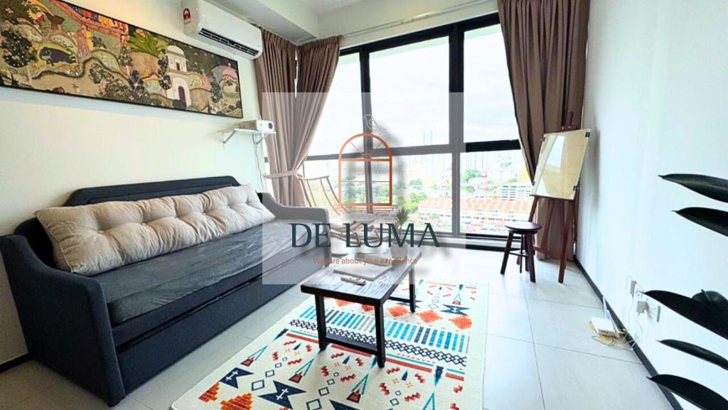a living room with a couch and a table at DeLuma-Urban Suites in Jelutong