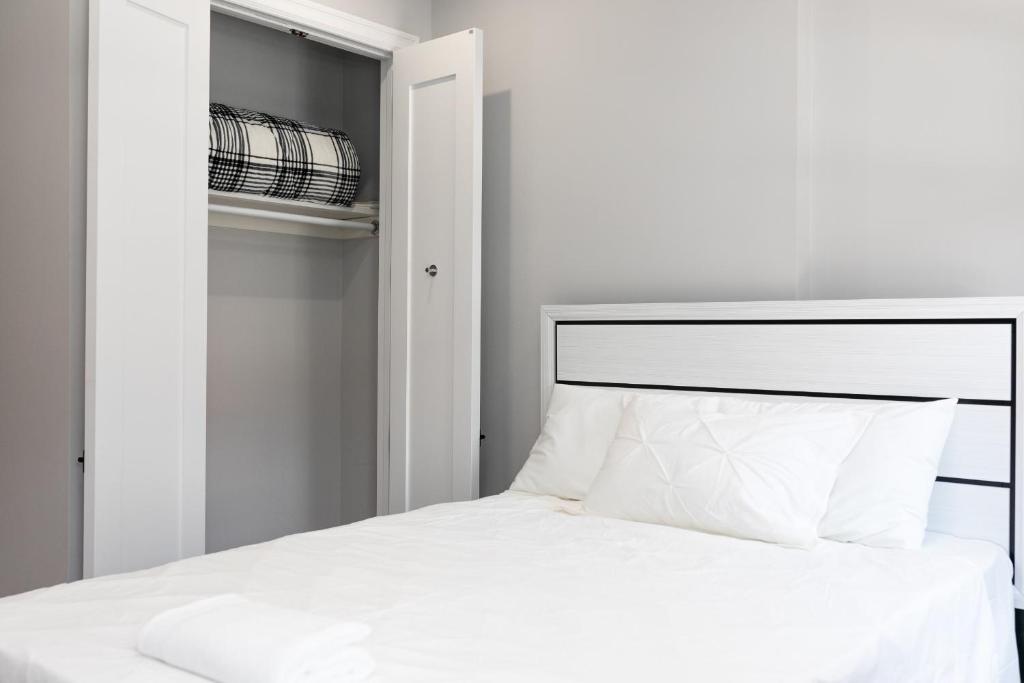 ein Schlafzimmer mit einem weißen Bett und einem Schrank in der Unterkunft Misbau home in Brooklyn