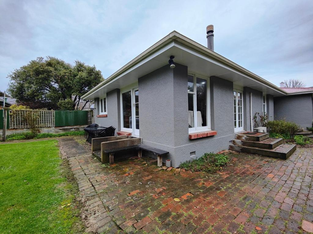 a small house with a patio and a yard at Peaceful by the Park in Invercargill