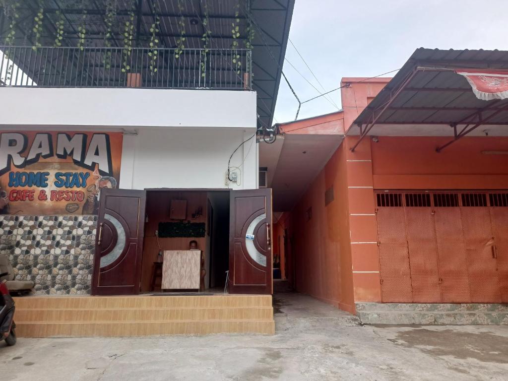 a building with two washing machines on the side of it at OYO 93333 Rama Home Stay in Jayapura