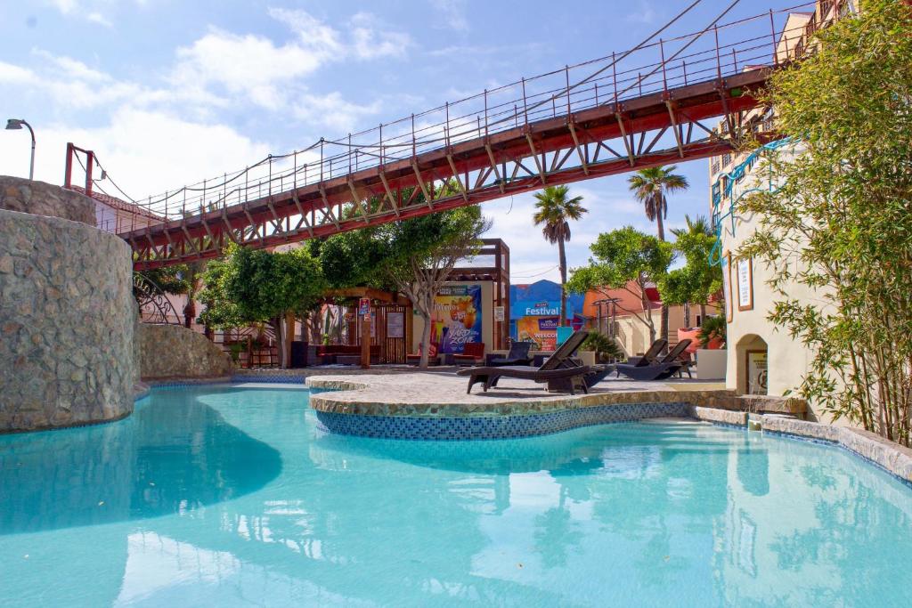 een groot zwembad met een brug erover bij Hotel Festival Plaza Playas Rosarito in Rosarito