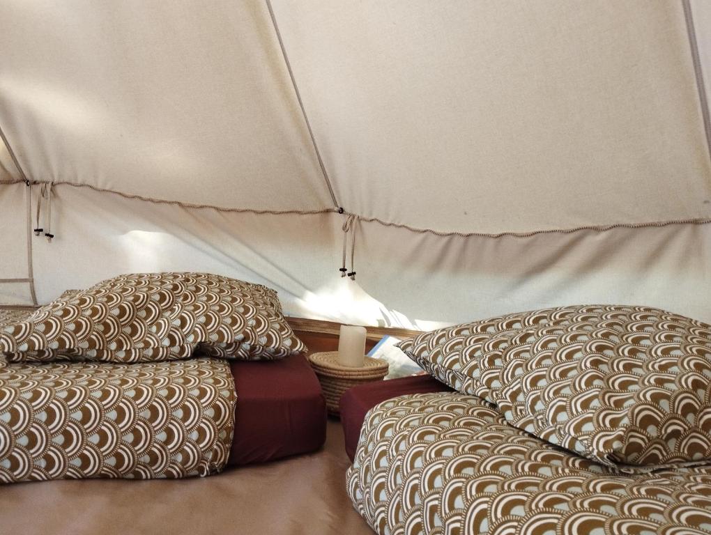 una habitación con 2 almohadas y una lámpara en una tienda de campaña en La Pause Mafate, en La Possession