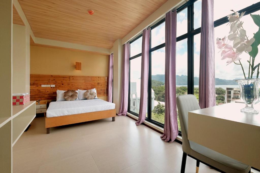 1 dormitorio con 1 cama y ventanas grandes en GHIELLANIQA INN, 
