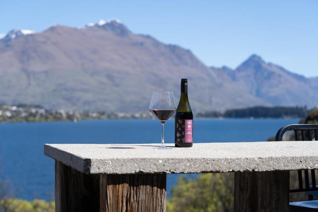 a bottle of wine and a glass sitting on a table at Te Wai • Luxe @ The Lake • in Queenstown