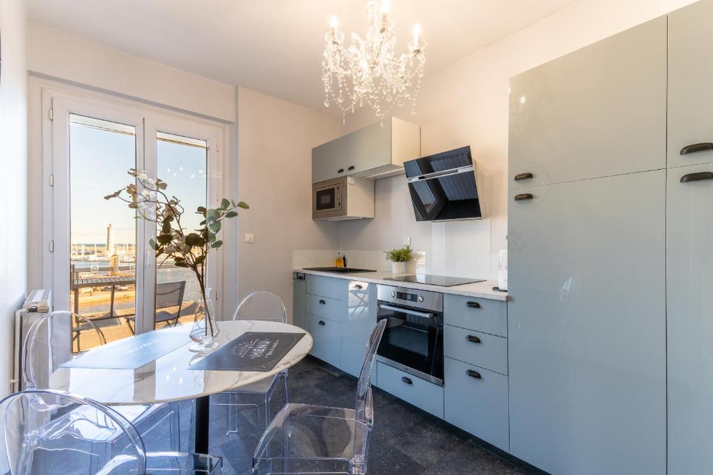 una cucina con un tavolo e un frigorifero bianco di La Petite Venise a Sète