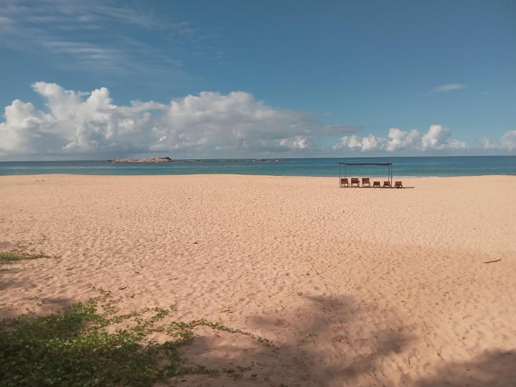 uma praia com um banco e um golo em Sena Home em Ambalangoda