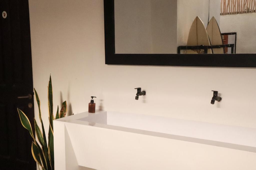 a bathroom with a white counter with a mirror at Best Canggu Hostel in Canggu