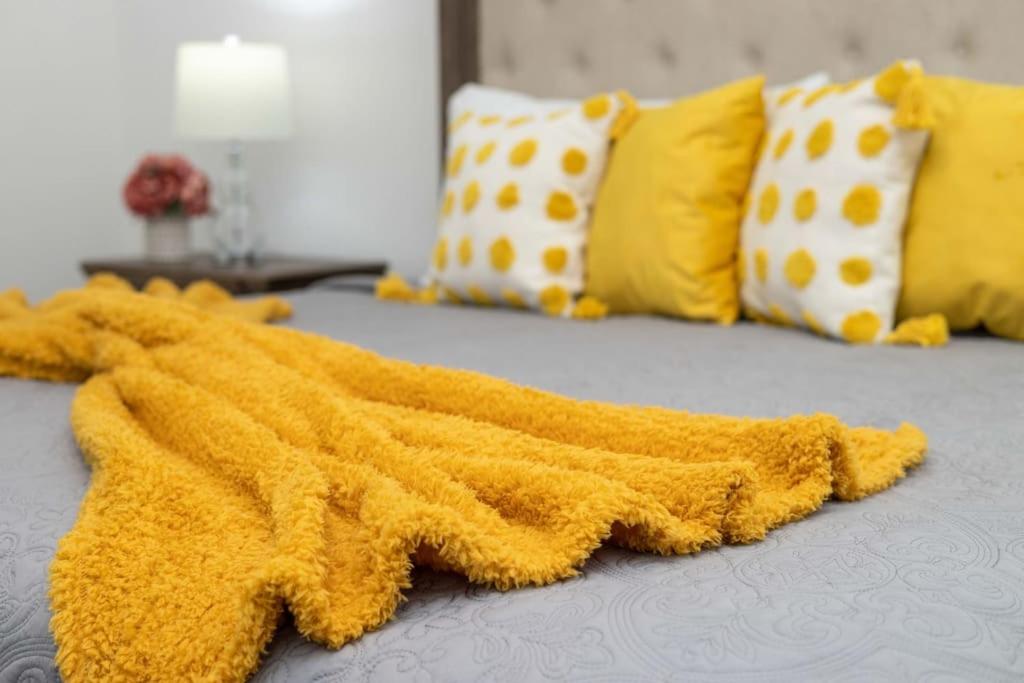 a yellow blanket laying on top of a bed at The Luxurious Château in Kingston