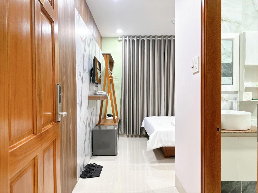 a room with a bathroom with a sink and a bed at Milan Homestay - Milanesa Hotel and Apartment in Vung Tau
