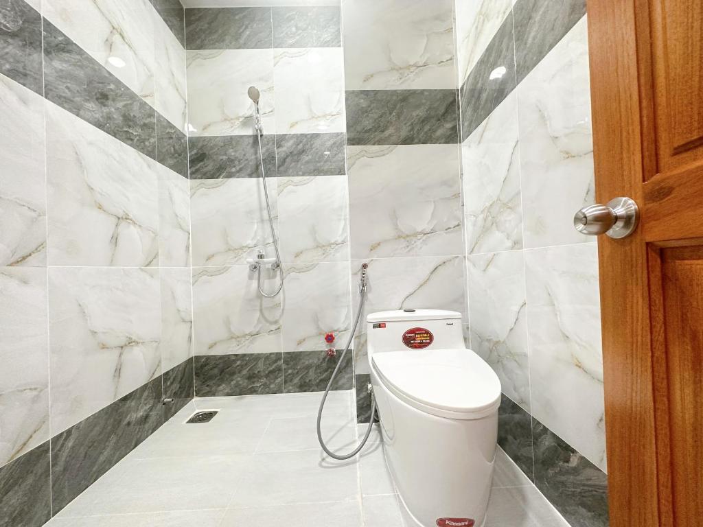 a bathroom with a toilet and a shower at Milan Homestay - Milanesa Hotel and Apartment in Vung Tau