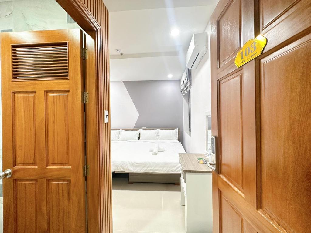 a door leading to a bedroom with a bed at Milan Homestay - Milanesa Hotel and Apartment in Vung Tau
