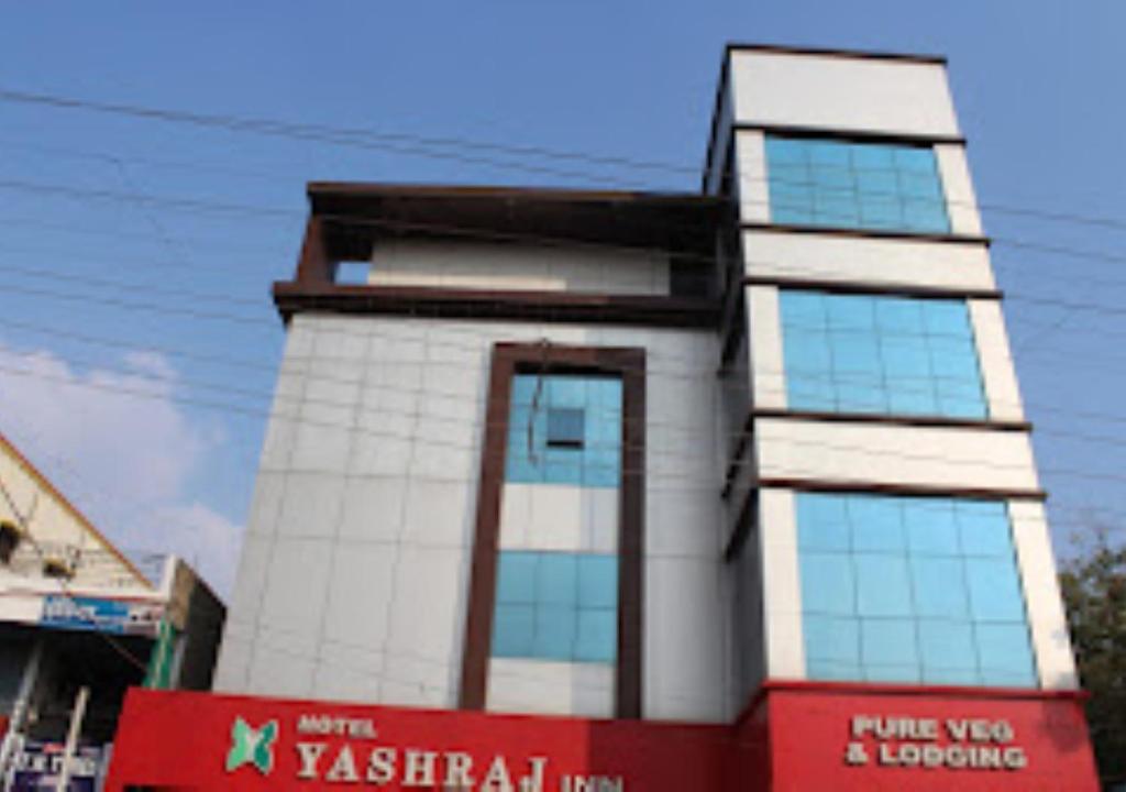 a tall white building with windows on a street at Hotel Yashraj Inn Beed in Bīr