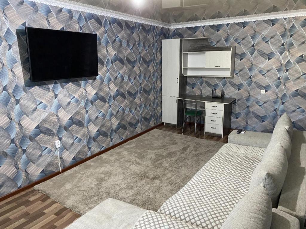 a living room with a tv on a wall at Мангилик ел 19 in Sätbaev