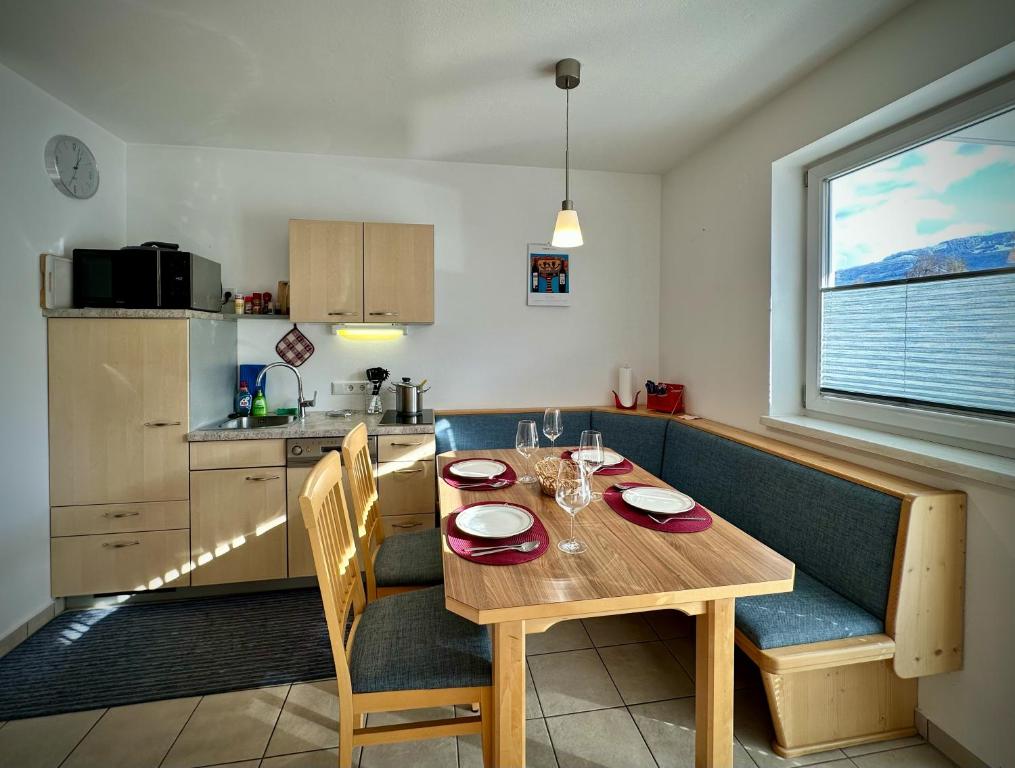 cocina y comedor con mesa de madera y sillas en Apartment Kitzsteinhorn, en Piesendorf