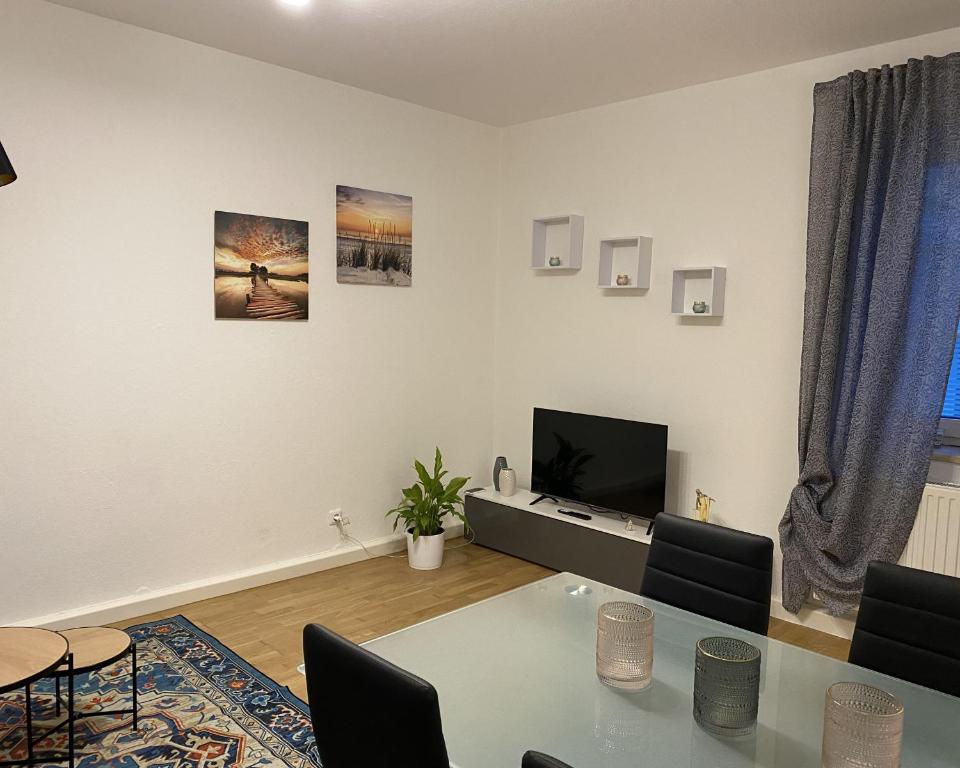 een woonkamer met een tafel en een televisie bij Private Wohnung direkt im Zentrum in Braunau am Inn