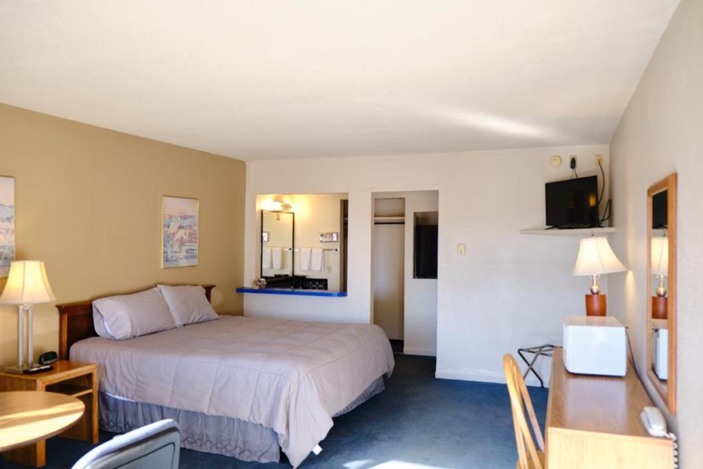 een hotelkamer met een bed en een bureau bij High Chaparral Inn in Rocky Ford