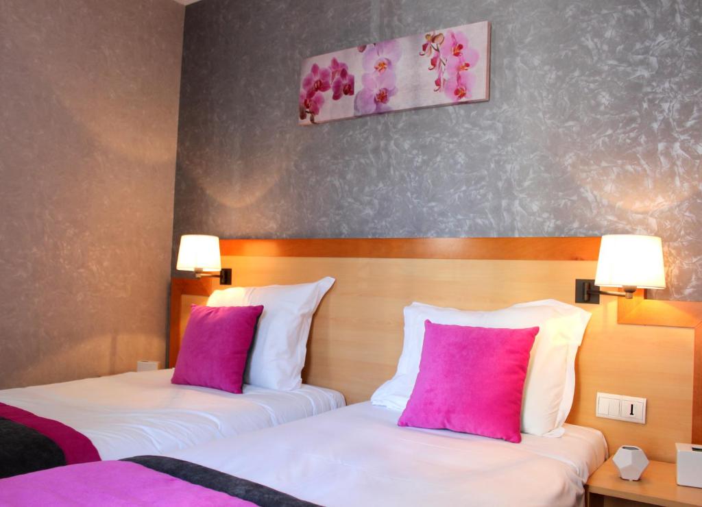 - 2 lits dans une chambre d'hôtel avec des oreillers roses dans l'établissement Hotel du Chemin Vert, à Paris