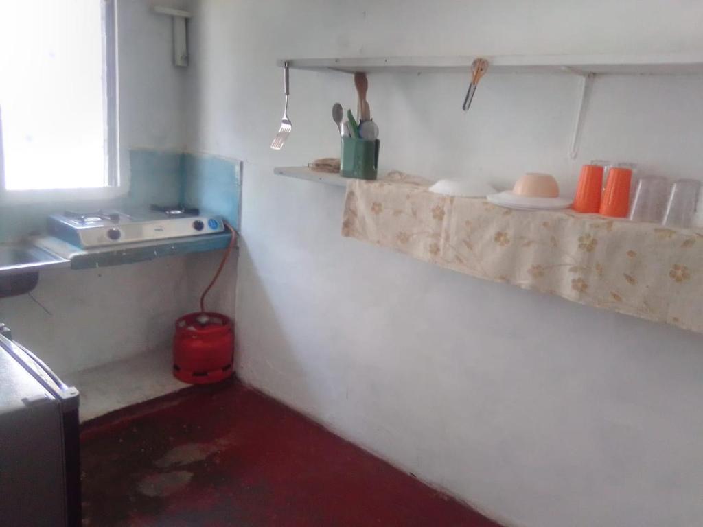 eine Küche mit Regalen an der Wand und einem Herd in der Unterkunft Gemütlich Green house in Mombasa