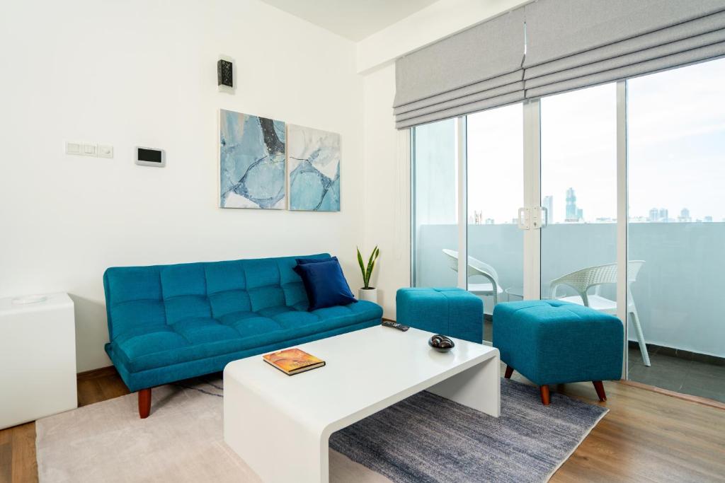 sala de estar con sofá azul y sillas azules en Hotel Style Colombo Studio Apartment, en Colombo