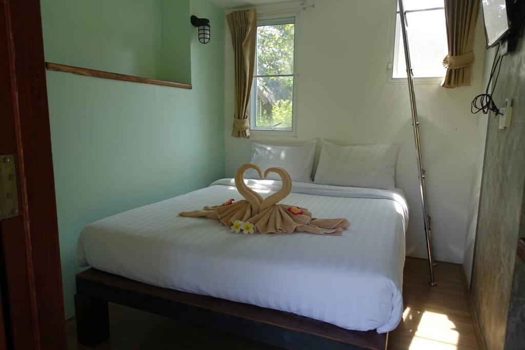 Un dormitorio con una cama con un corazón. en Koh Mak Living, en Ko Mak