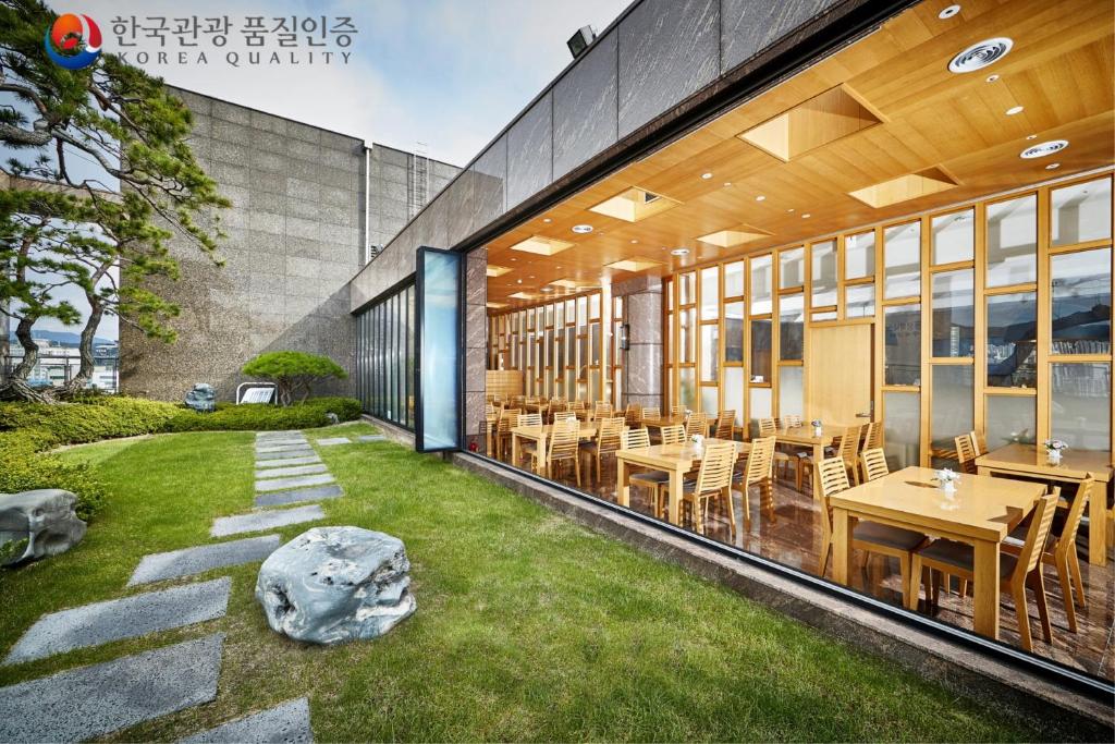 a restaurant with tables and chairs in a building at Arban Hotel in Busan