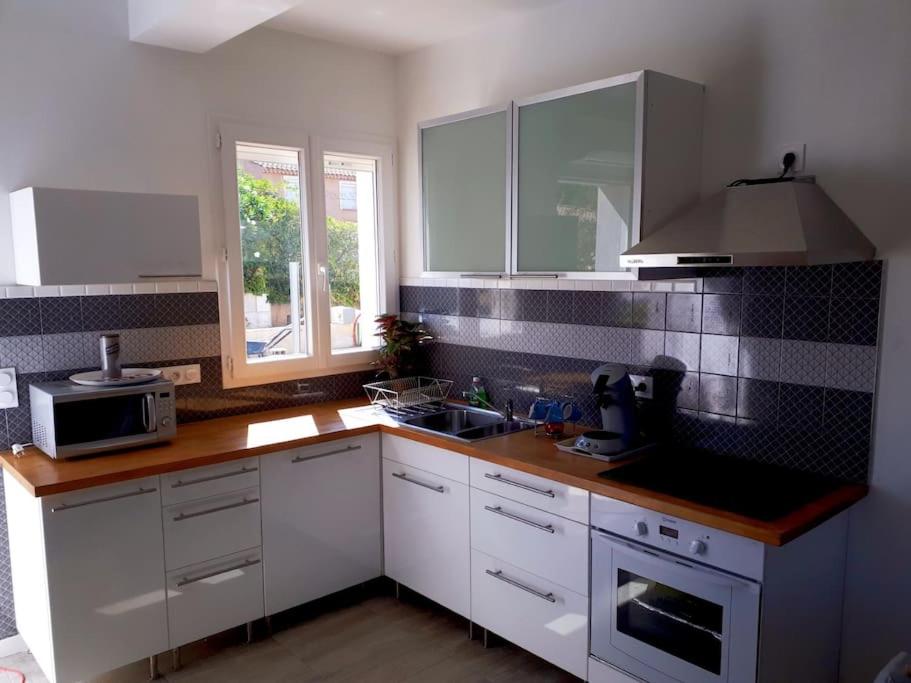 a kitchen with white cabinets and a counter top at Duplex 5 p 40m2 jardin de 50m2 in Six-Fours-les-Plages