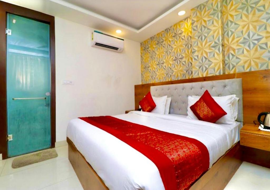 a bedroom with a large bed with red pillows at Hotel Glace Airport Stay Near IGI Airport in New Delhi