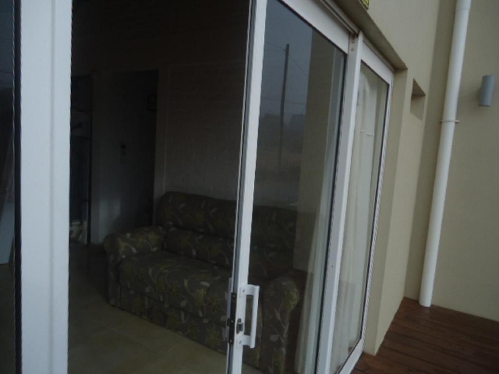 a living room with a sliding glass door with a couch at Estrella de la viuda in Punta Del Diablo