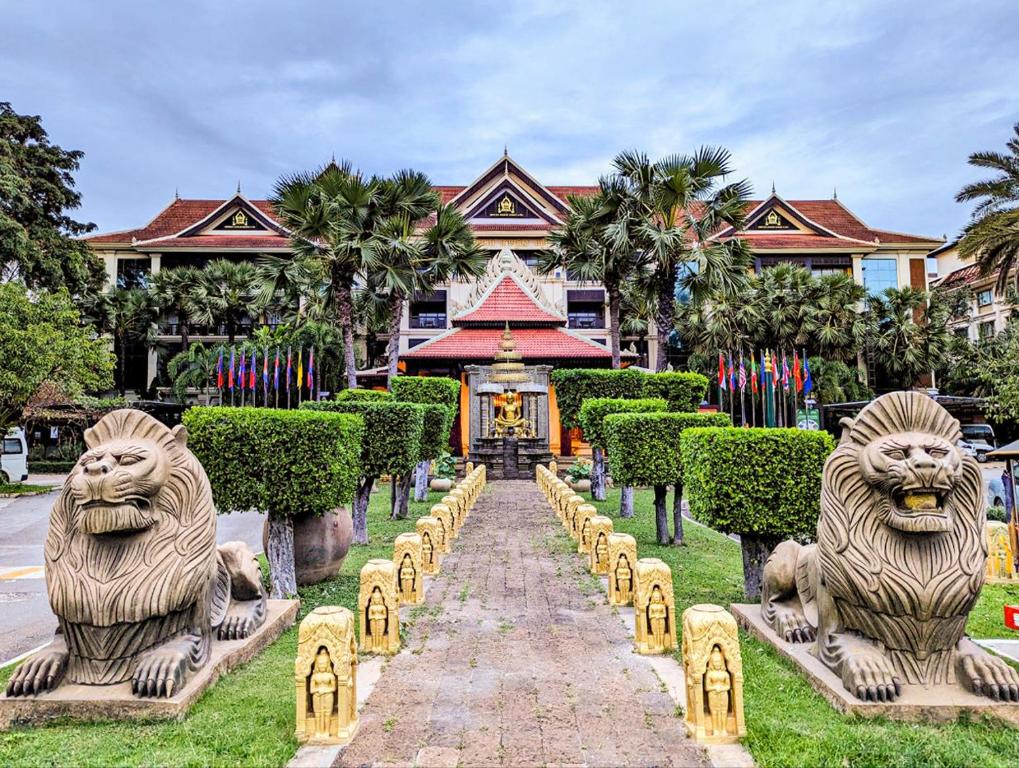 duas estátuas de leões em frente a um edifício em Empress Angkor Resort & Spa em Siem Reap