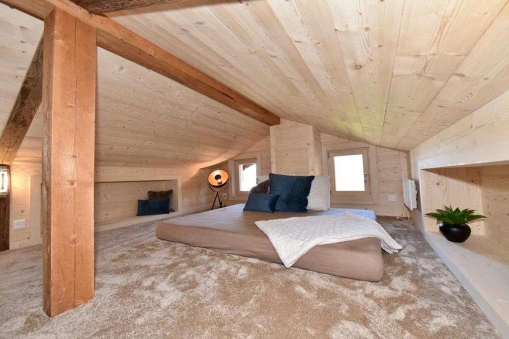 a bedroom with a large bed in a room with wooden ceilings at Chalet a Didi - Alps Paradise - 4 Vallees in La Tzoumaz
