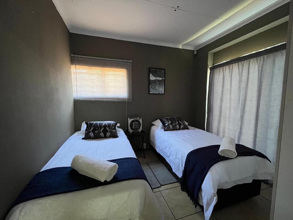 a bedroom with two beds and a window at 1 on Titania in Polokwane