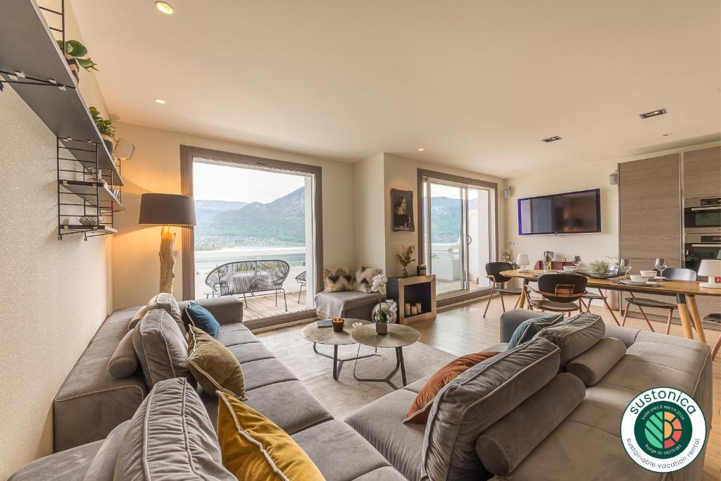 uma sala de estar com um sofá grande e uma mesa em Annecy Lake, Luxury top floor apartment - LLA Selections by Location Lac Annecy em Annecy