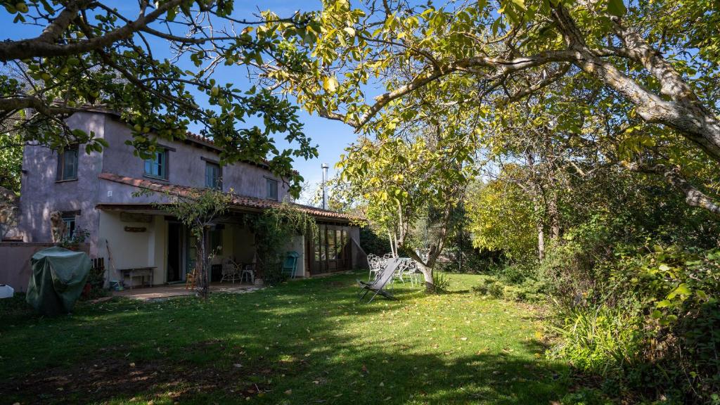 uma casa velha com um quintal em frente em El Zarzal em Horche