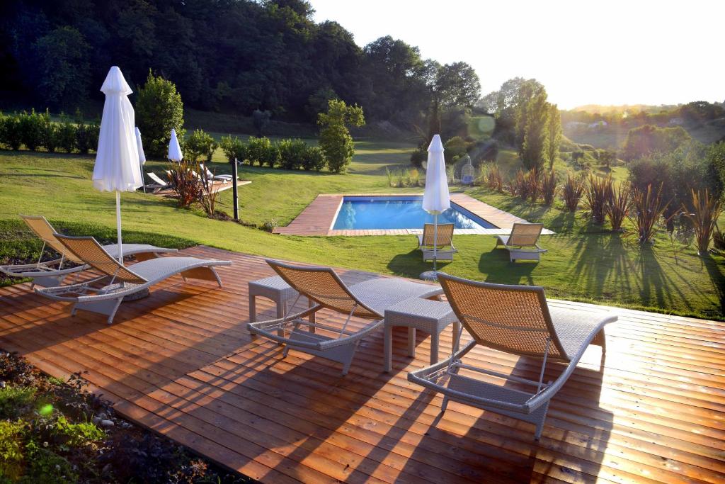 a deck with chairs and umbrellas next to a pool at Country House I Lauri in Montefiore dellʼAso