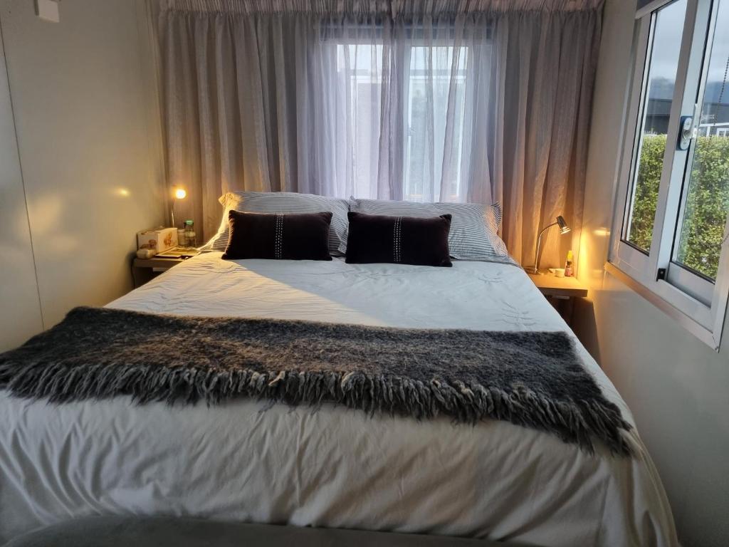 a bedroom with a large bed in front of a window at Queen Street Holiday Park in Richmond