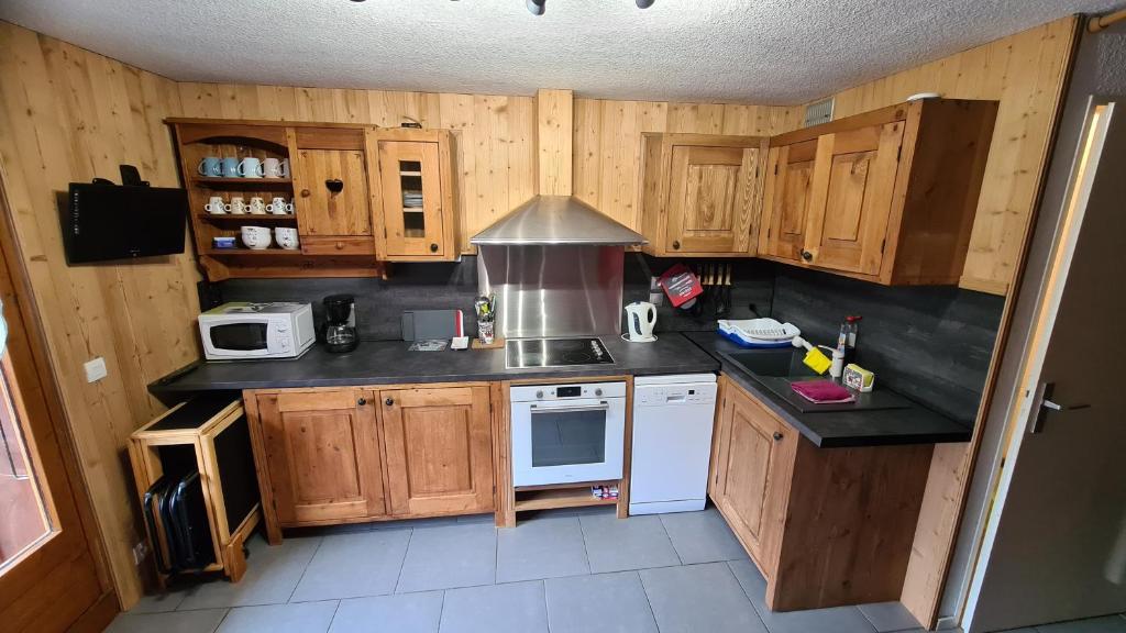 a small kitchen with wooden cabinets and white appliances at Chalet La Piste Bleu in Saint-Gervais-les-Bains