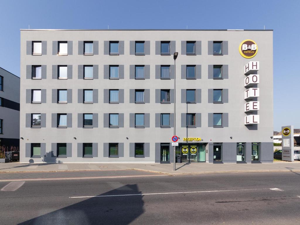 een wit gebouw met een bord aan de zijkant bij B&B Hotel Neuss in Neuss