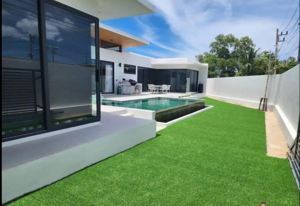 an image of a backyard with a swimming pool and grass at Villa WANNY in Nathon Bay