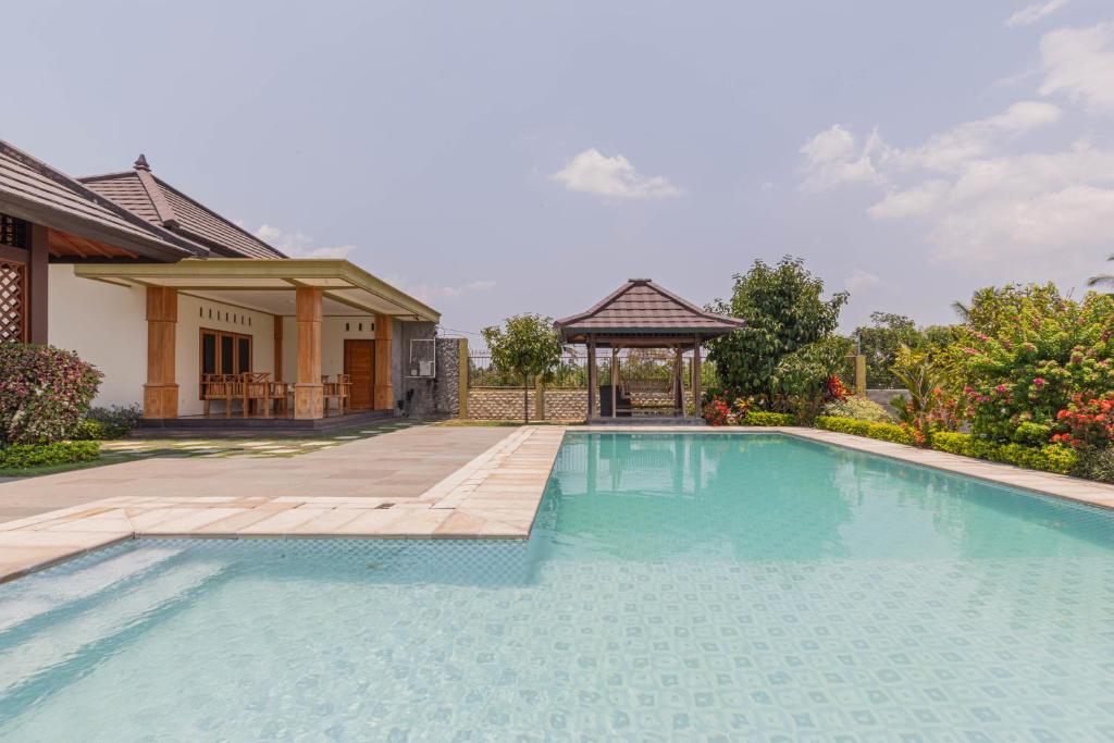 a swimming pool in front of a house with a gazebo at Bait Nahwa in Mataram