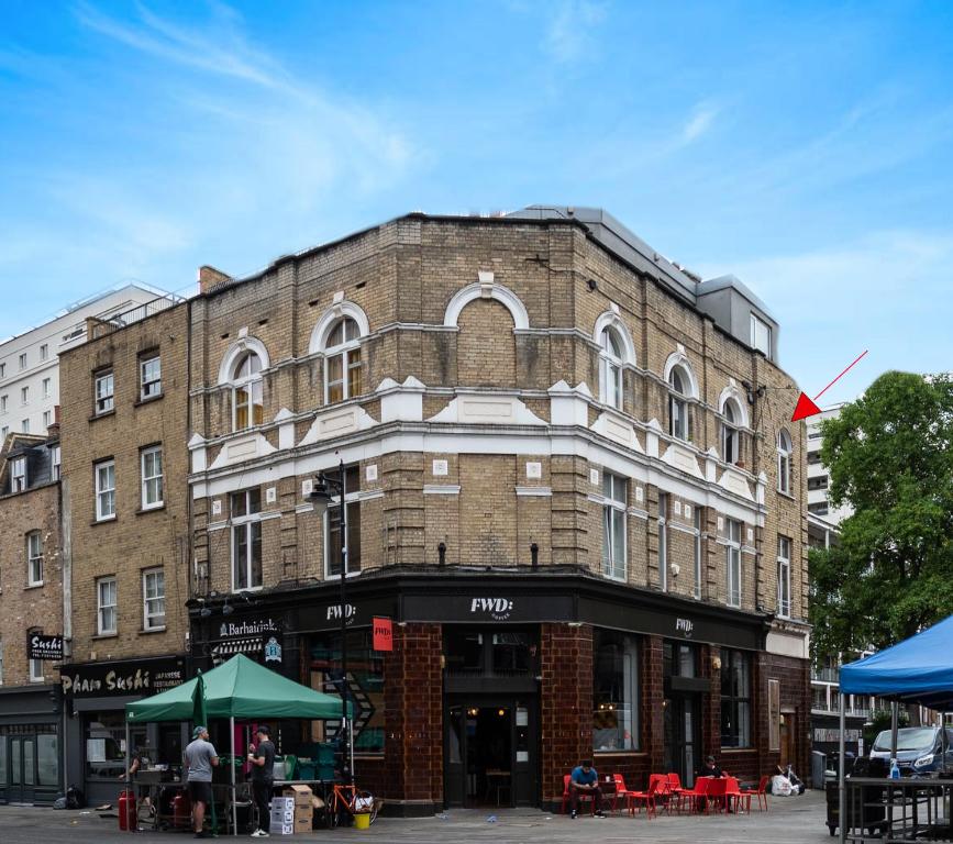 a large brick building on a city street at Cosy 1-Bed Apartment in Central London Old Street in London