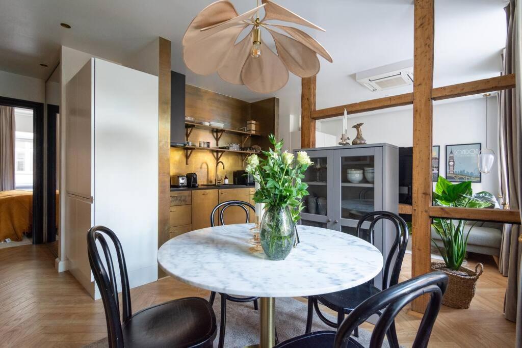 a dining room table with chairs and a vase of flowers at Extravagant-2 bedrooms-Bronze in Copenhagen