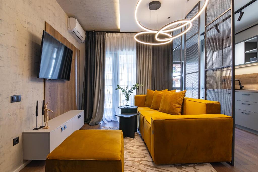 sala de estar con sofá amarillo y lámpara de araña en Expozitiei ap. 13 en Baia Mare