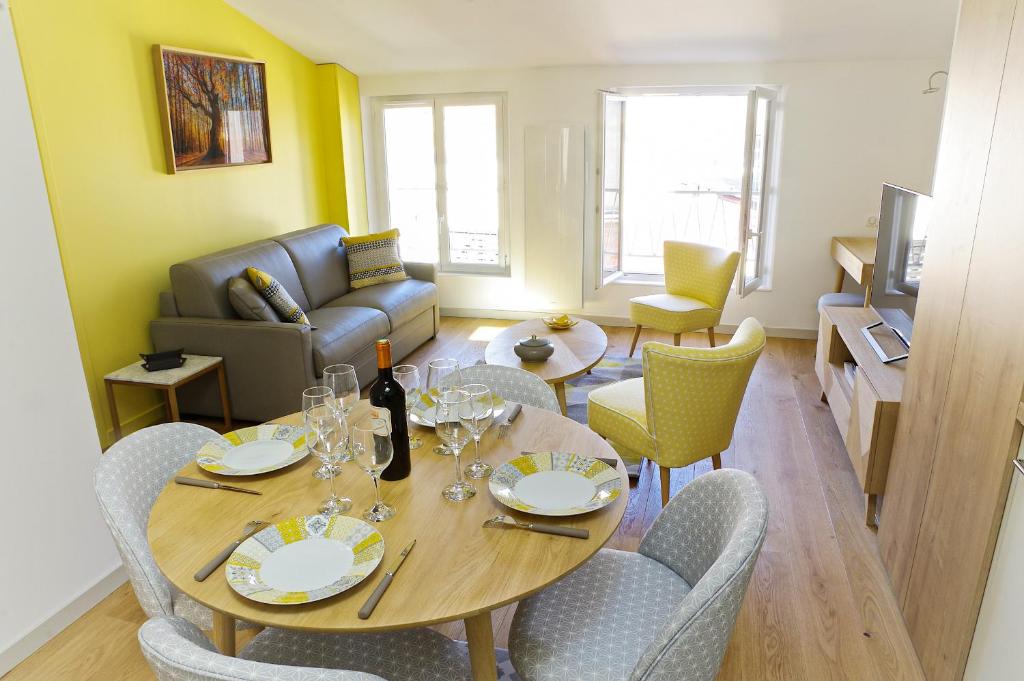 un salon avec une table, des chaises et un canapé dans l'établissement Fondaudège - Appartement 1 chambre avec parking, à Bordeaux
