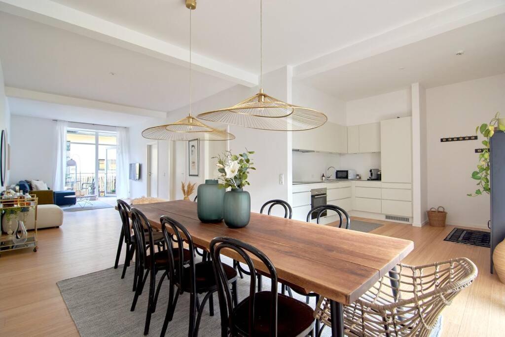 a kitchen and dining room with a wooden table and chairs at Nordic style top location balcon in Copenhagen