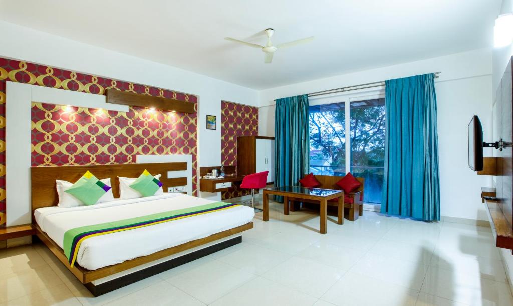 a bedroom with a bed and a desk and a window at Treebo Trend New Plus Point in Bangalore