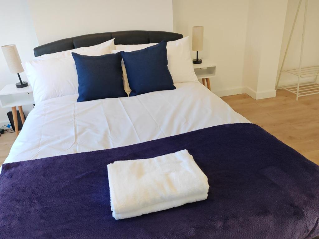 a large bed with blue and white pillows and a white and blue blanket at Charming 5 Bedroom House in Bexley in Bexley