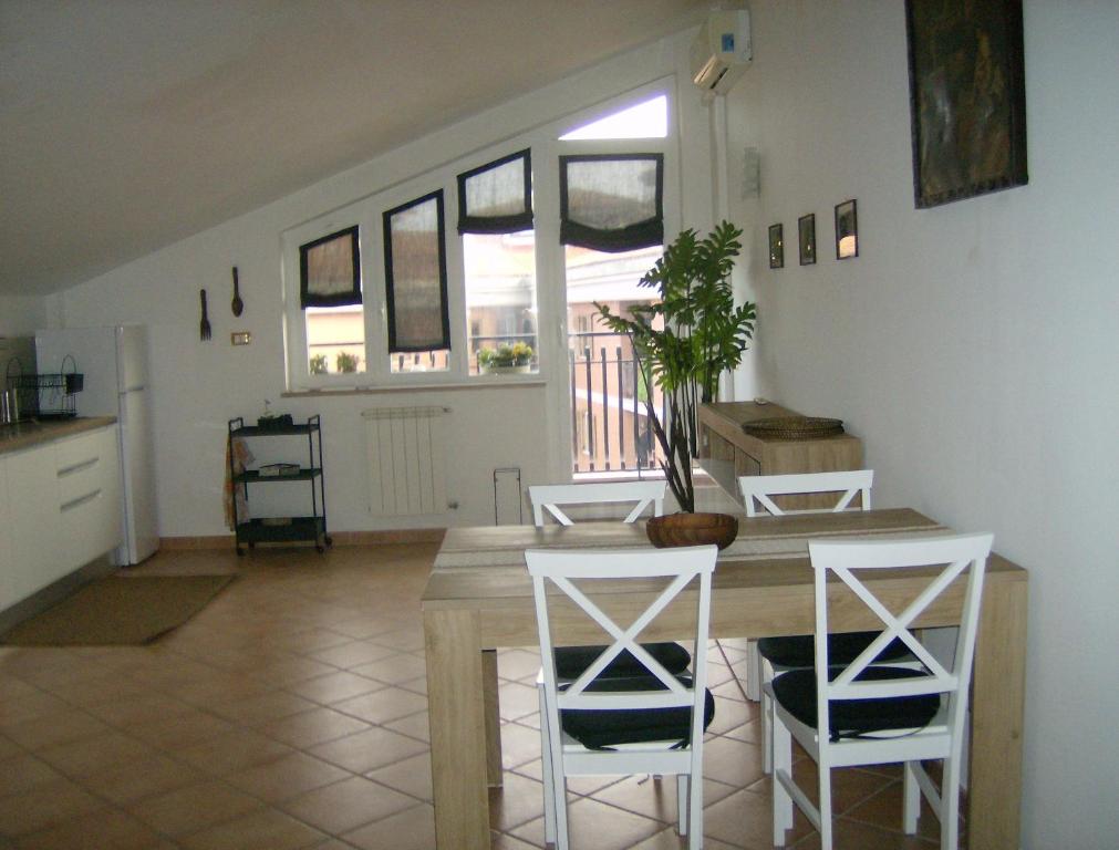 een keuken en eetkamer met een tafel en stoelen bij La mansarda di Matteo in Bracciano