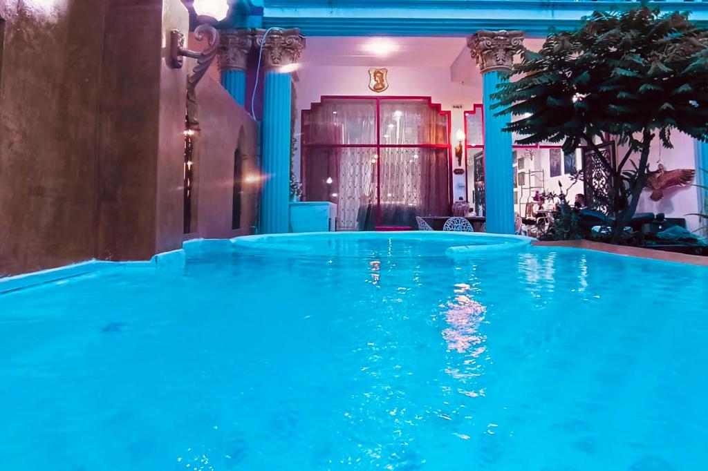 a large swimming pool with blue water in a room at Mandala Beach Villa Jomtiean in Jomtien Beach