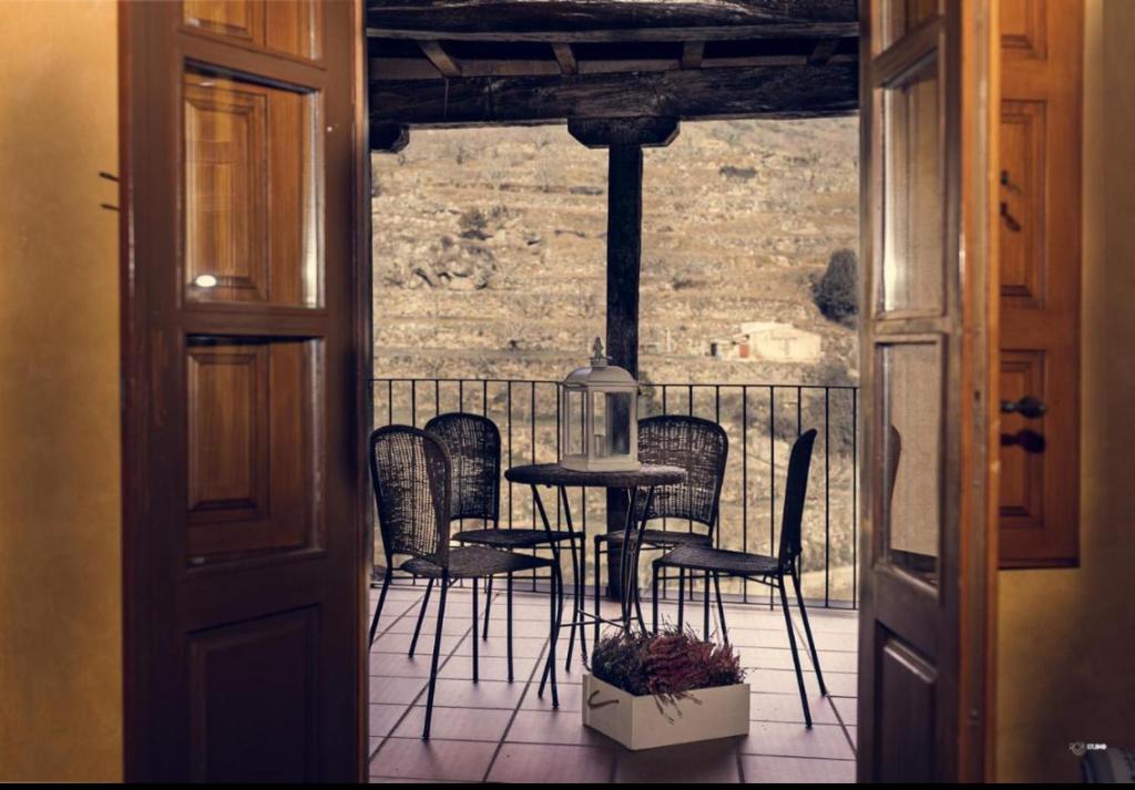 a room with a table and chairs on a balcony at APARTAMENTOS RURAL LA JACOBA in Cabezuela del Valle