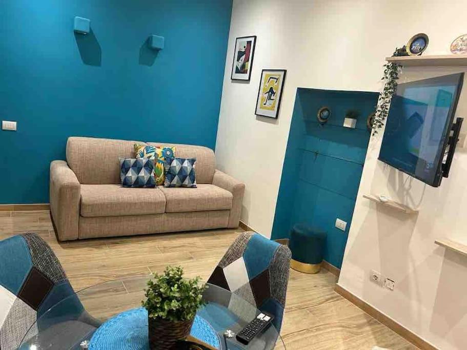 ein Wohnzimmer mit einem Sofa und einem TV in der Unterkunft Bayres Blue in Mailand
